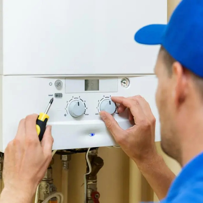 hvac technican working on a boiler